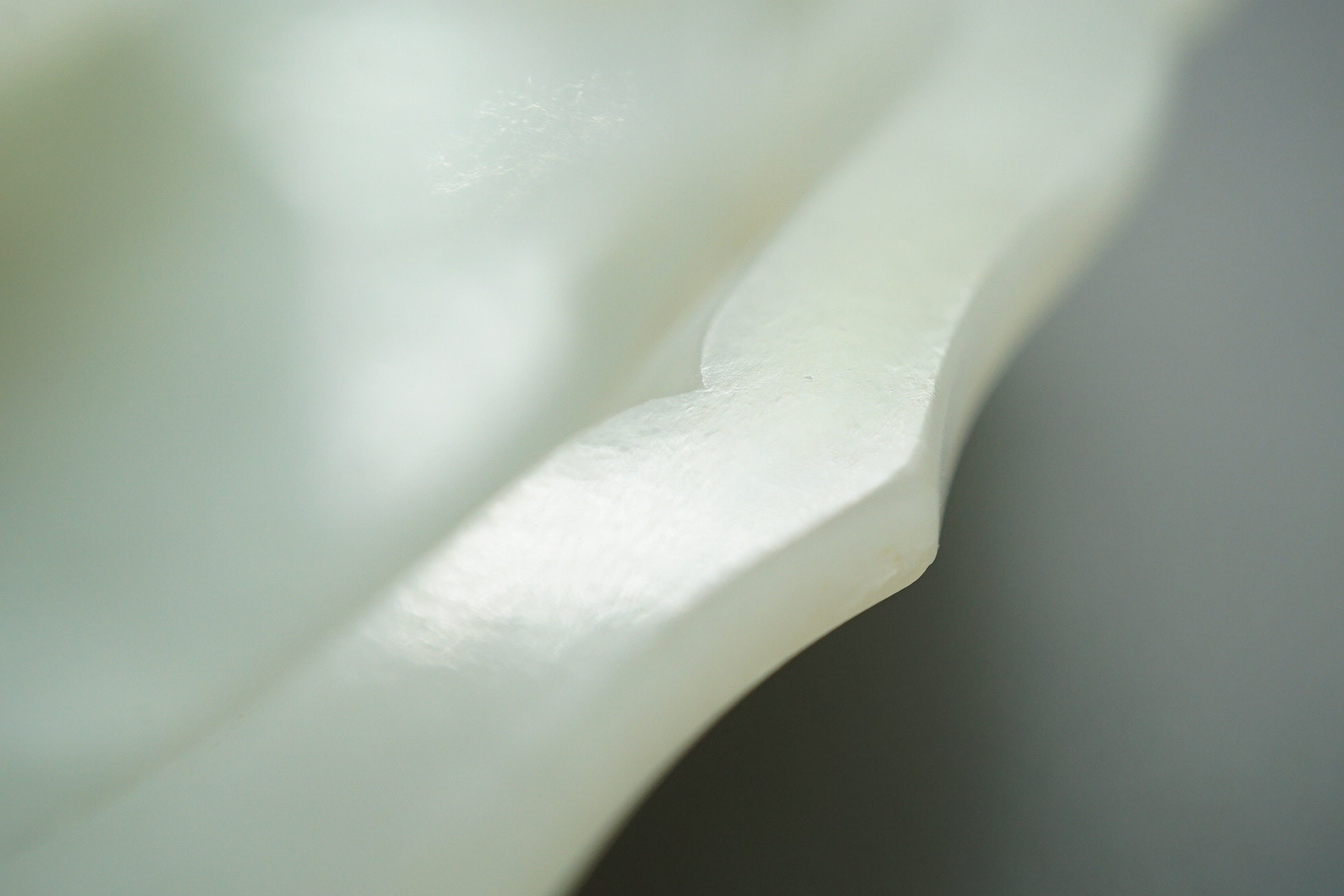 A Chinese white and russet jade petal lobed cup stand